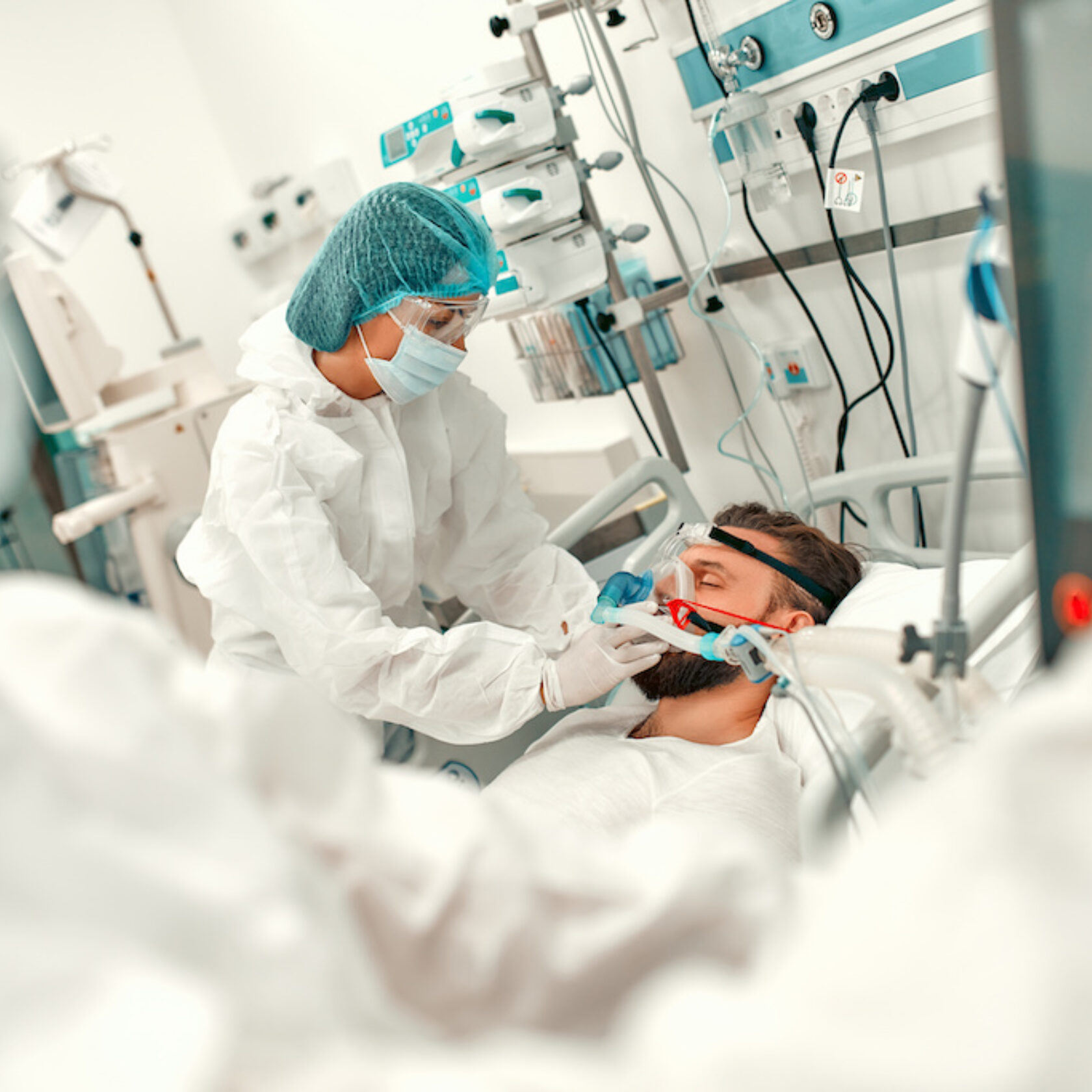Patient wird auf der Intensivstation von zwei Pflegekräften betreut